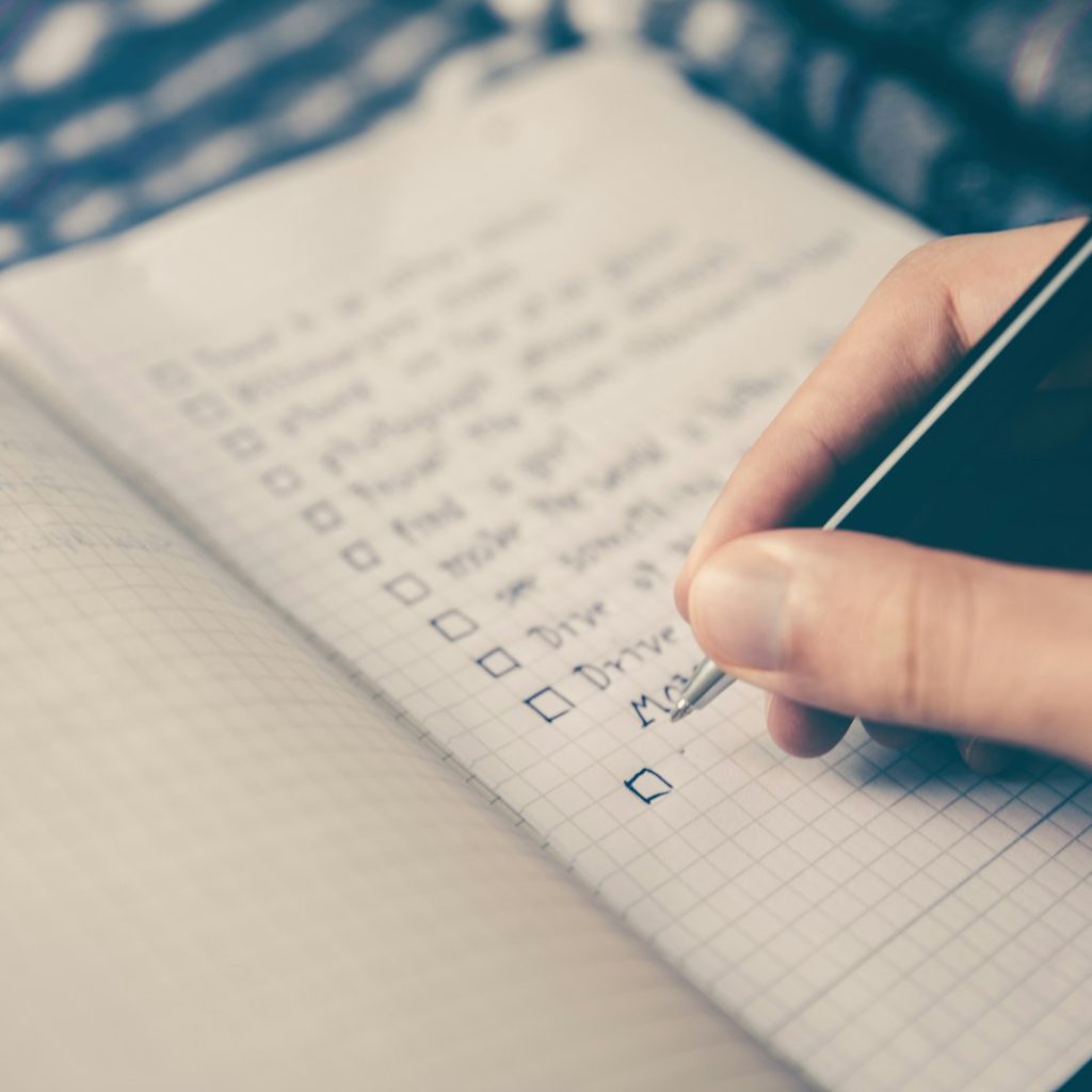 Person writing goals in a notebook representing personal growth and focus